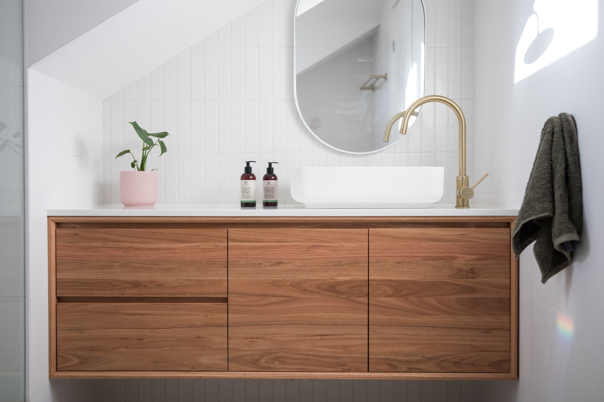 Brass tap on white timber vanity