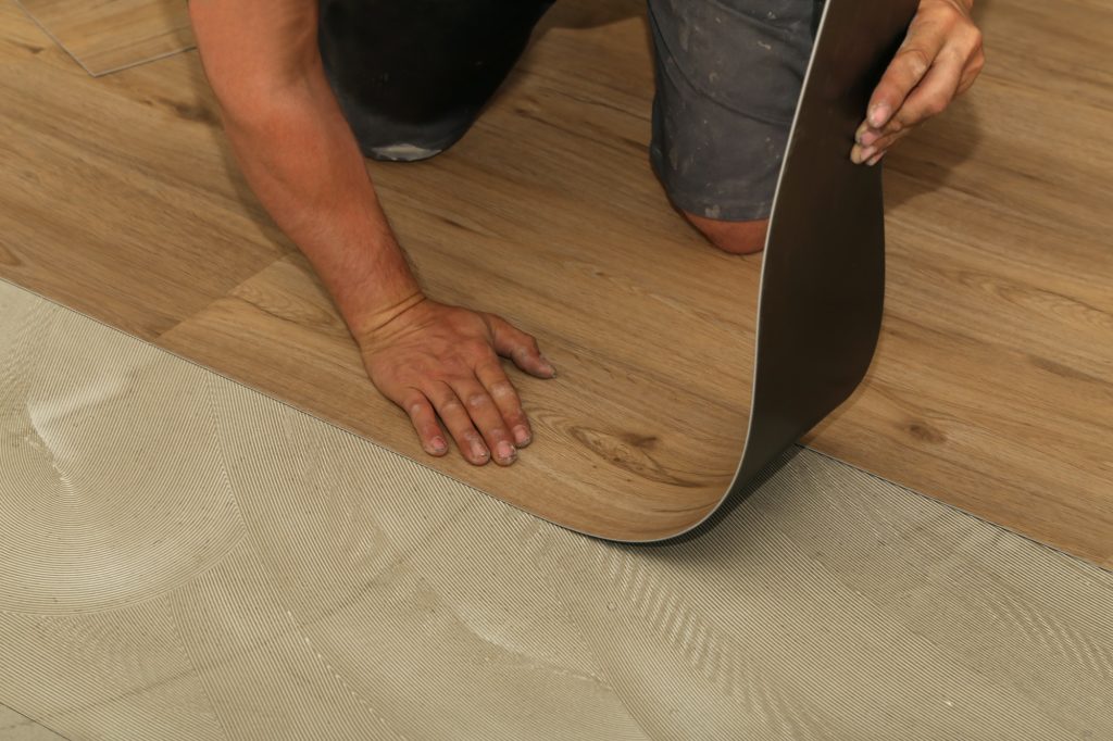 Worker installing new vinyl tile floor